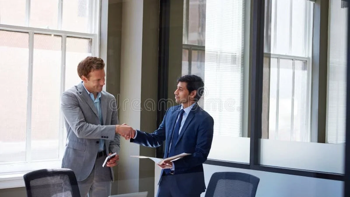 Smiling client shaking hands with attorney after receiving substantial personal injury settlement check for car accident injuries